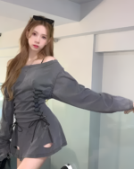 Woman wearing a gray Grunge-Style Dress with lace-up detailing and cutouts.