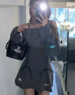 Woman wearing a Grunge-Style Dress with lace detailing, holding a handbag.