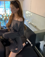 Woman wearing a Grunge-Style Dress, off-shoulder, sitting on a sofa.