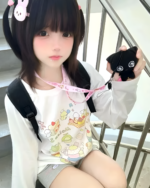 Person wearing a Harajuku Desserts T-Shirt with a bunny plushie.