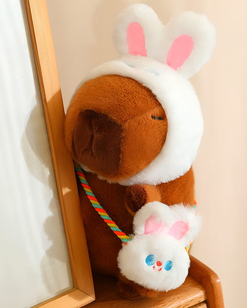 Hatted capybara plushie with a bunny hat and strap, designed as a squeaky purse. Features a cute face and soft fur.
