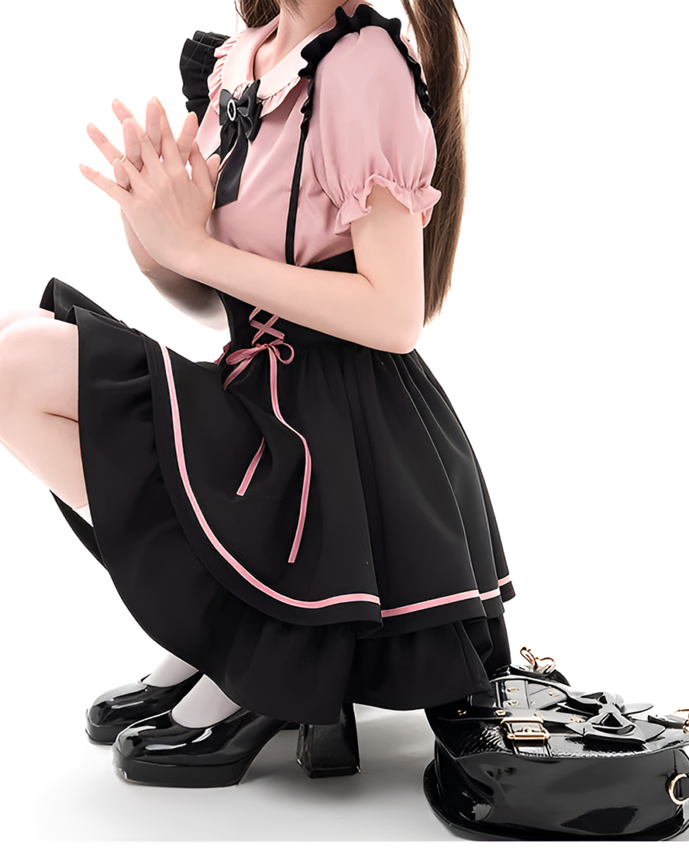 Pink and black Jirai Kei outfit with lace-up pinafore and ruffled details. Features a coordinating top and high-heeled shoes.