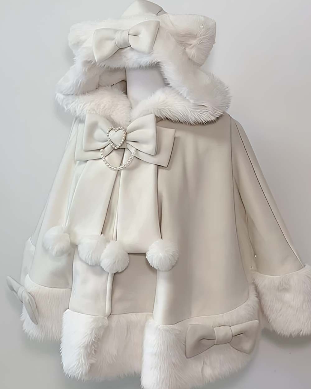 White hooded Cat Eared Cloak featuring a bow and decorative pom-poms.
