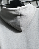 Close-up of a gray Harajuku aesthetic hoodie, featuring a textured fleece fabric and hood.