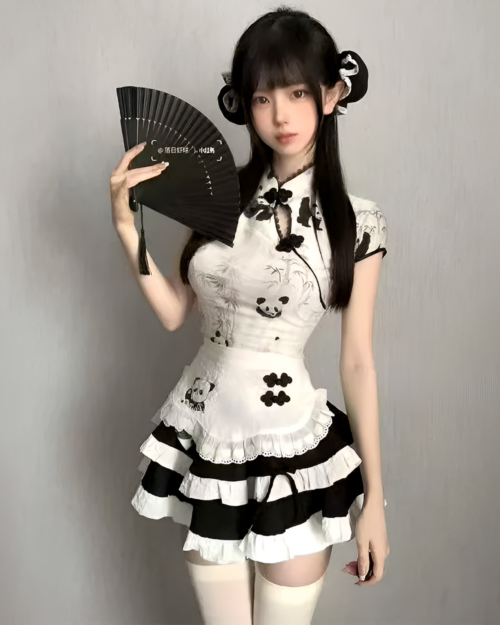 Woman in a panda maid dress with a black and white design, holding a folding fan. The dress features panda illustrations.
