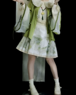 Model wearing the Jade Blossom Neo-Hanfu set, a green and white traditional Chinese outfit. This Neo-Hanfu set features layered details.