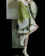 Model wearing a Jade Blossom Neo-Hanfu set in green and white. This Neo-Hanfu set features a flowing silhouette and delicate floral details.