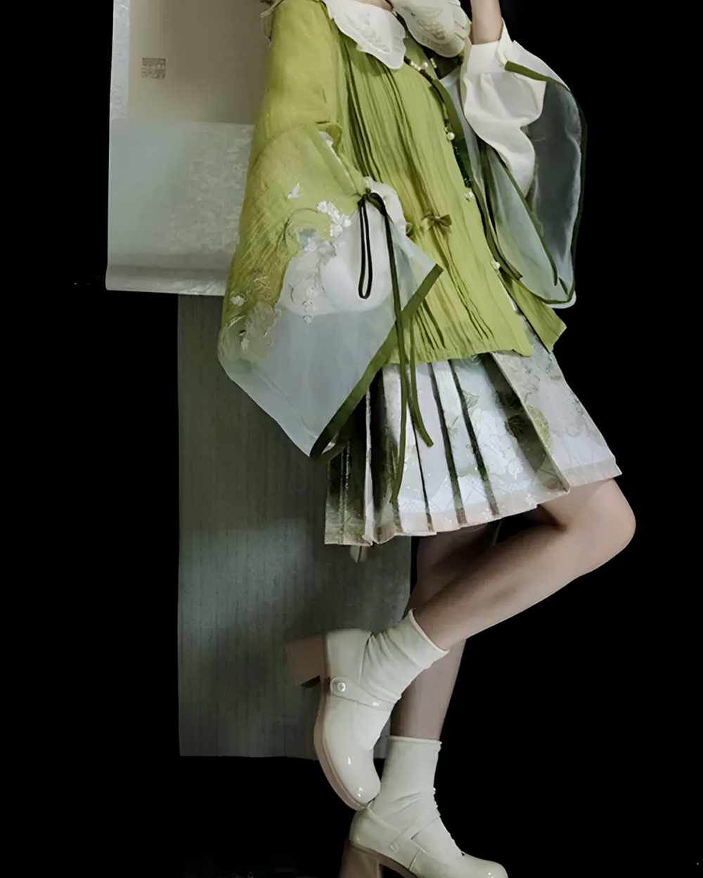 Woman wearing a green Jade Blossom Neo-Hanfu set with floral details and white boots. A modern take on traditional Chinese clothing.