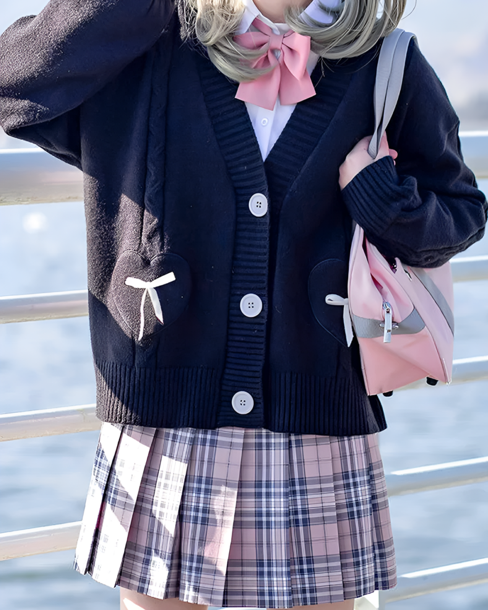 Black Japanese knitted cardigan with bear appliques, worn by a student with a plaid skirt.