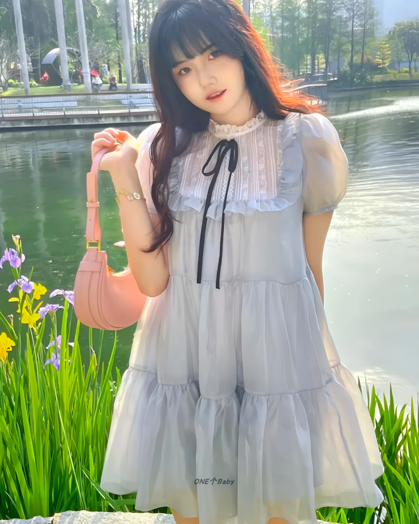 Woman wearing a light blue Japanese mesh dress with ruffles outdoors.