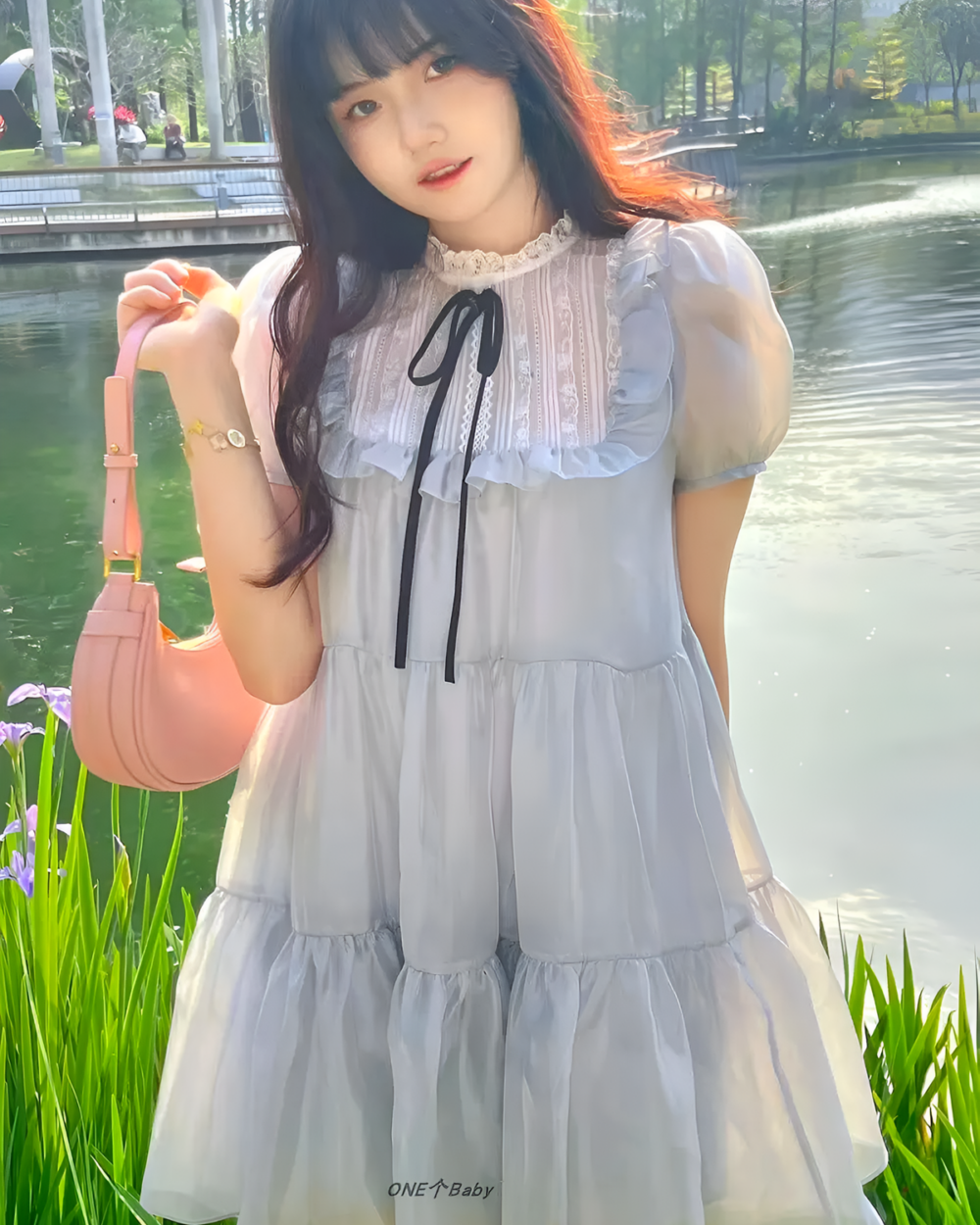 Woman wearing a gray japanese mesh dress with lace details, by the water.
