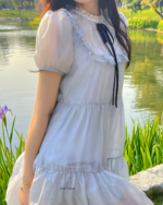 Woman wearing a white japanese mesh dress with lace details and a black ribbon.