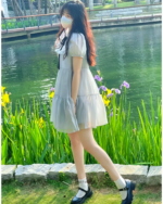 Woman wearing a grey japanese mesh dress by a lake.