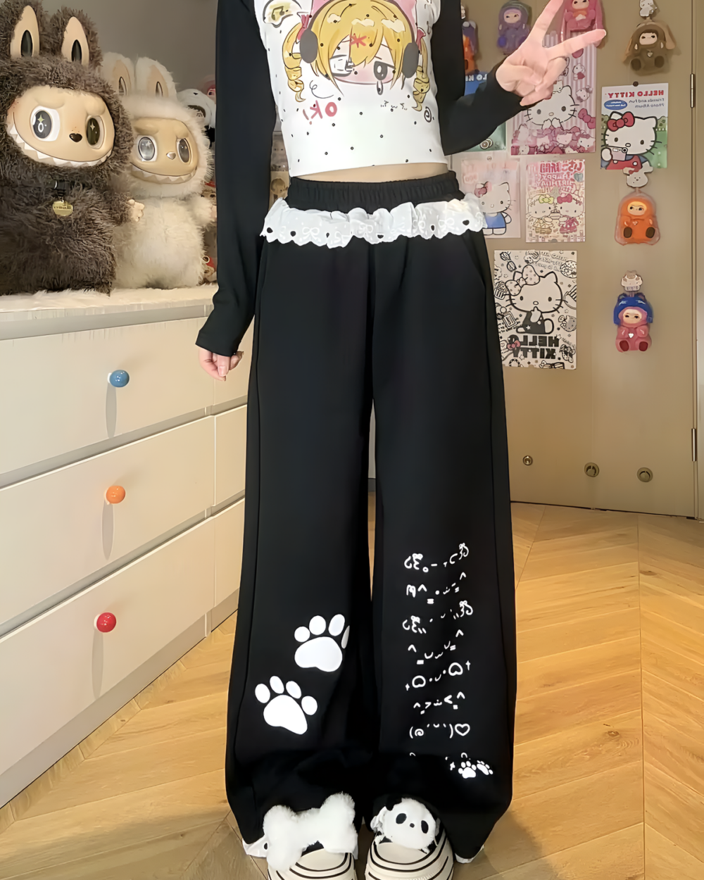Black pants with Kaomoji paw print design, cutecore aesthetic.