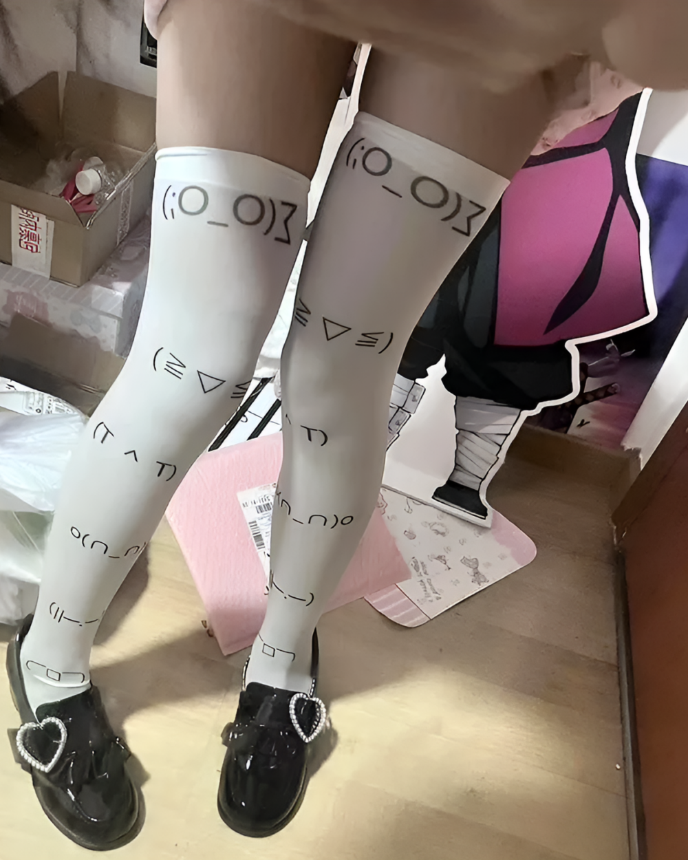 Close-up of black kaomoji stockings with printed symbols and heart decorations.