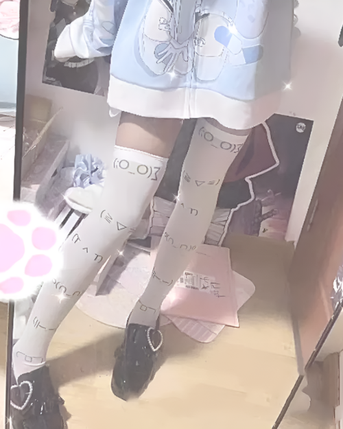 Kaomoji stockings on legs, featuring printed emoticons and a layered design.