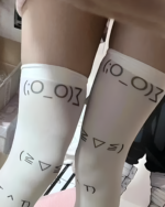Kaomoji stockings with emoji designs on white legwear.