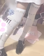 Kaomoji stockings, long socks with cute emoticon designs, visible on a leg.