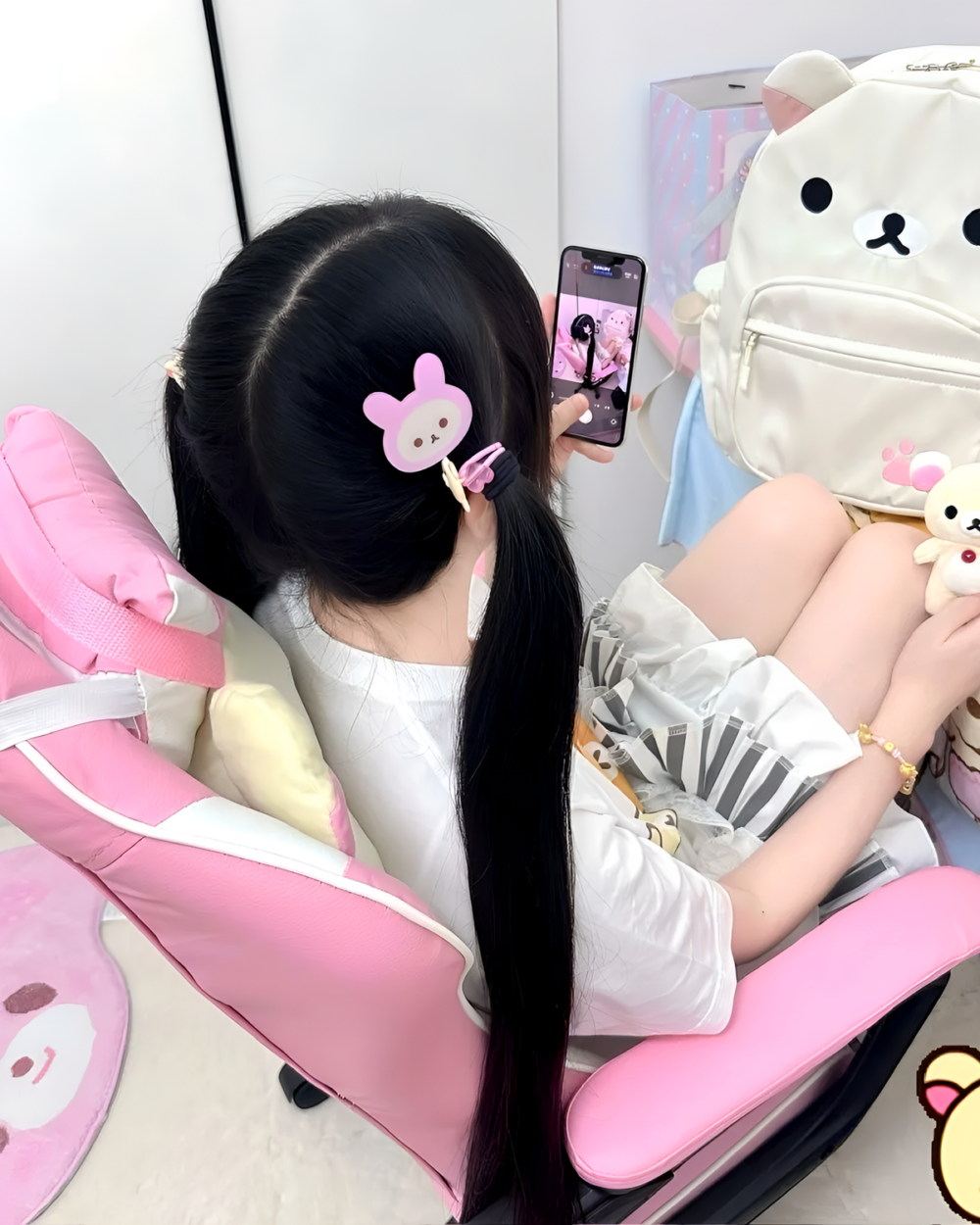 Woman using phone with a cream Kawaii Bear Backpack by Jojifuku. Includes a bear hair clip and plush toys.