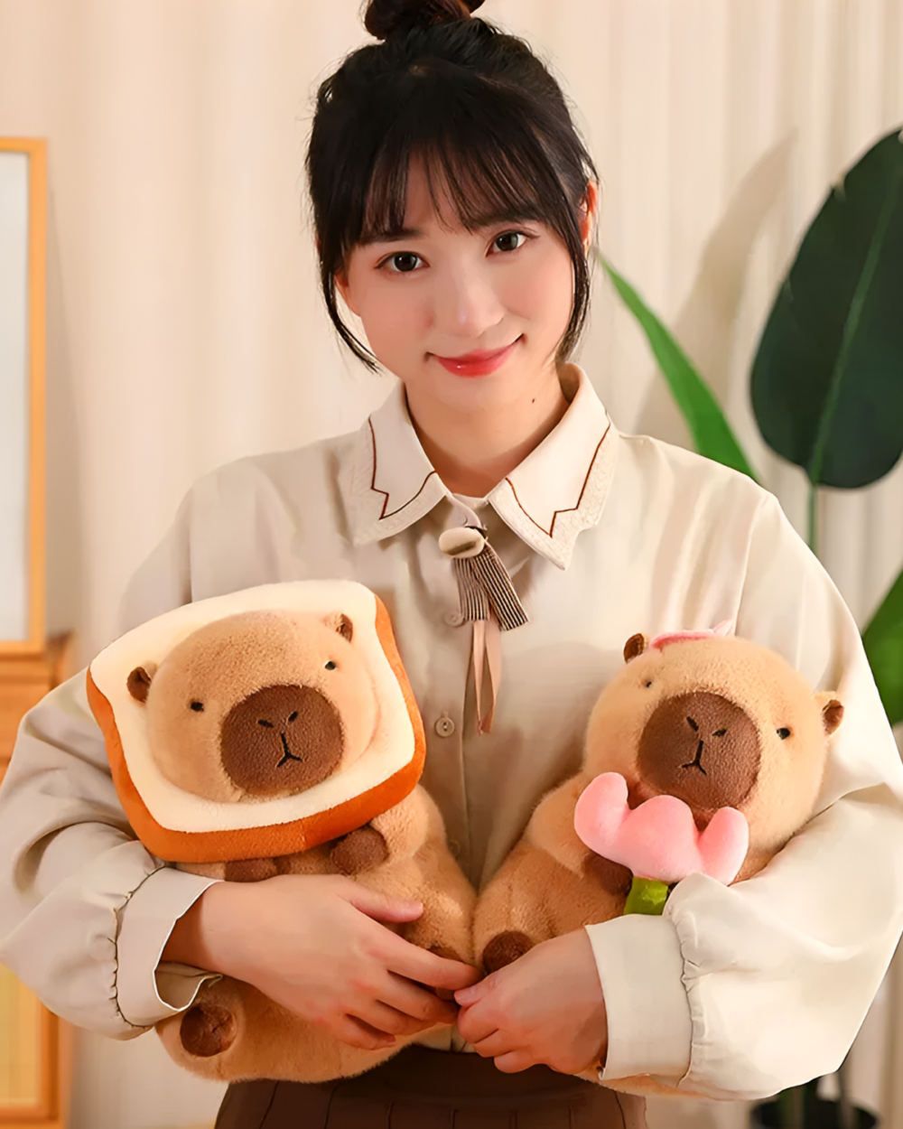 Woman holding two Kawaii Capybara Plushies - Bread & Flower Edition. These adorable capybara plushie toys feature unique bread and flower designs.
