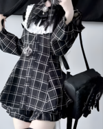 Model wearing a black and white plaid Jirai Kei dress with long sleeves and a pleated skirt. Includes a bag and gloves.