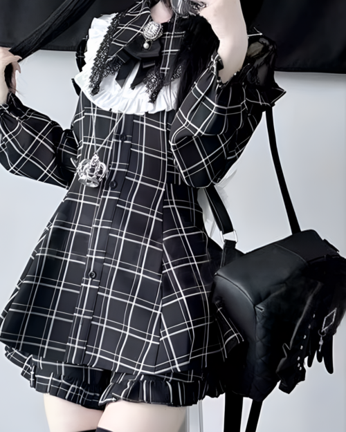 Model wearing a black and white plaid Jirai Kei dress with long sleeves and a pleated skirt. Includes a bag and gloves.