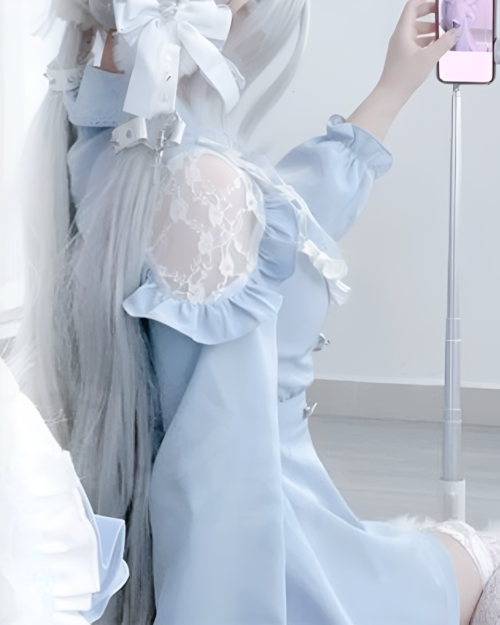 Light blue Jirai Kei dress with lace details and long sleeves. A person is modeling the dress.