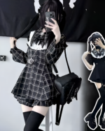 Woman wearing a black and white plaid Jirai Kei dress with lace details and a bow. Includes thigh-high socks.