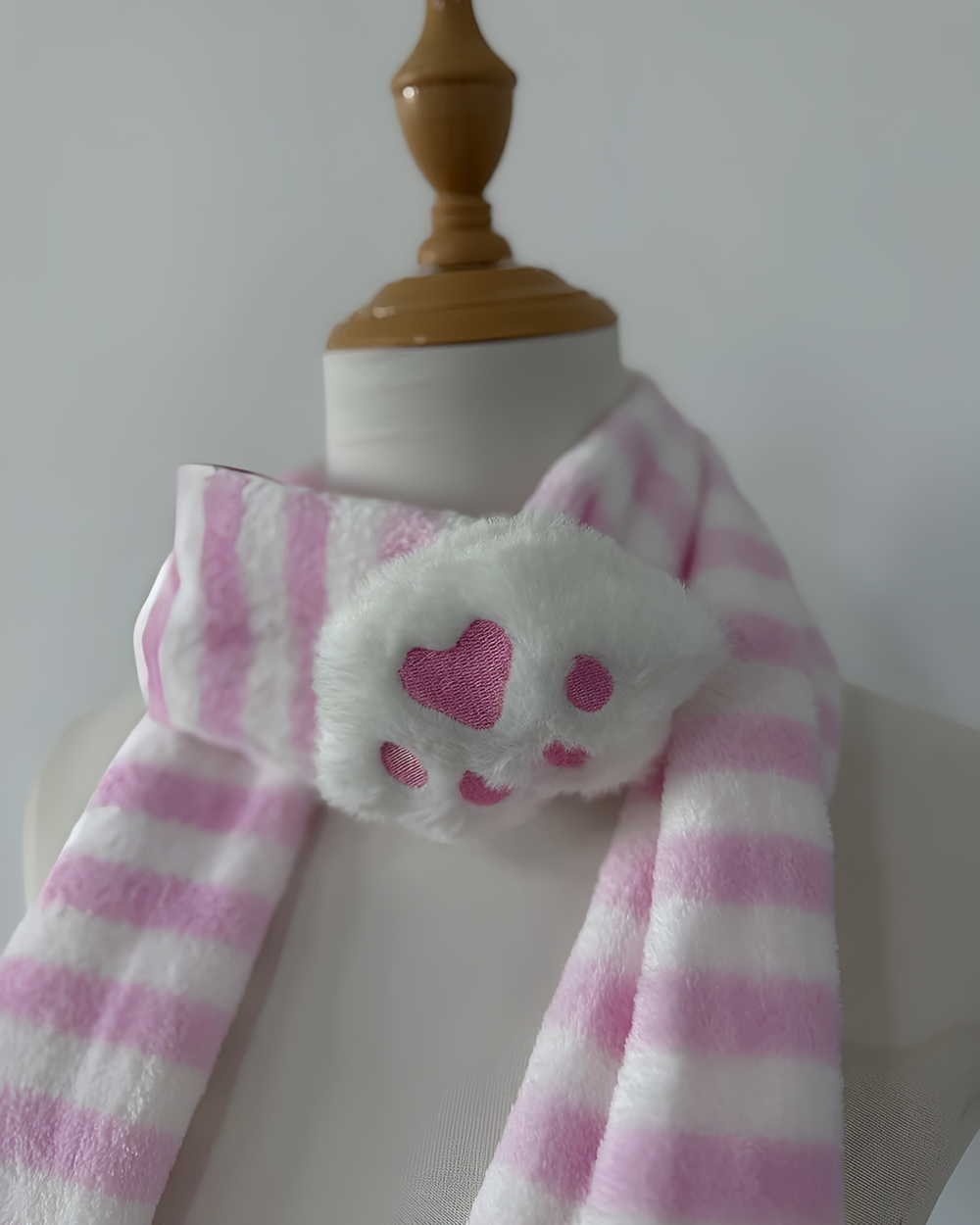 Pink and white striped Kawaii Neko Paw Scarf with a fluffy paw print detail, displayed on a mannequin.