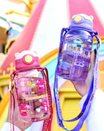 Transparent cute water bottle with a bear design and carrying strap.