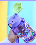 Close-up of a purple cute water bottle with a bear-shaped lid and colorful design.