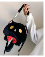 Hand holding a black Kawaii Phantom Neko Bag with a red bow and pearl strap. The bag is shaped like a cat’s face.