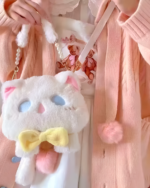 Close-up of a Kawaii Phantom Neko Bag hanging on a pink cardigan. The bag features a cat face design with a yellow bow.