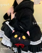 A person holding a black Kawaii Phantom Neko Bag shaped like a cat with pink ears and a red bow. The bag features a fluffy texture.