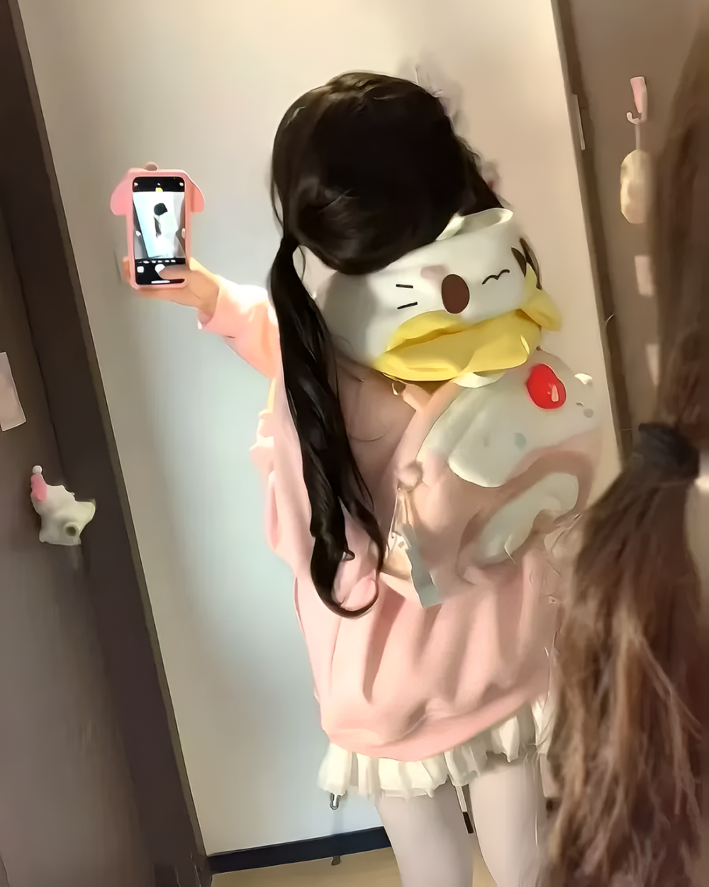 Person wearing a Kawaii Pink Neko Hoodie, holding a plush duck toy.