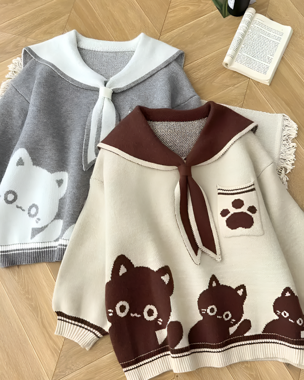 Two Kawaii Sailor Pullover Sweaters displayed. One is gray with a cat face, the other is cream with a paw print.