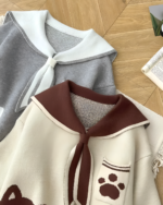 Close-up of a Kawaii Sailor Pullover Sweater featuring a navy collar and paw print design.