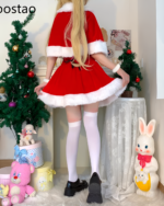 Woman wearing a red Kawaii Shawl Winter Dress with white trim, posing near Christmas decorations.