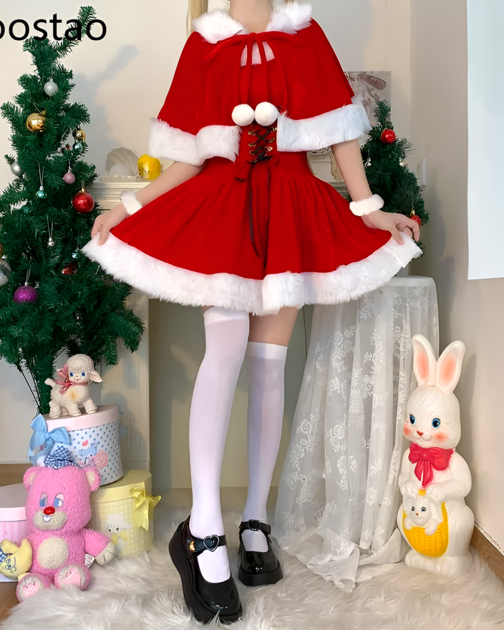 A woman wearing a red Kawaii Shawl Winter Dress with white fur trim, posing near a Christmas tree and decorations.