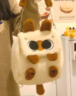 Close-up of a Kawaii Siamese Cat Plush Backpack with large eyes and fluffy pom-poms. A cute siamese cat backpack.