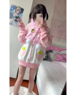 Pink strawberry bunny hoodie worn by a person in a bedroom setting.