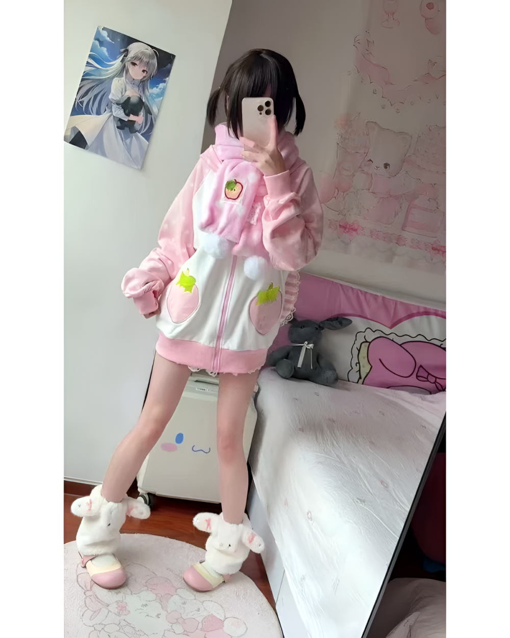 Person wearing a pink strawberry bunny hoodie and slippers in a bedroom setting.