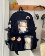 Black clear vinyl backpack featuring two vinyl pockets with plush toys inside.