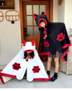 Two children wearing a black and white Kawaii Winged Eared Plush Cape with cute paw prints and animal ears.