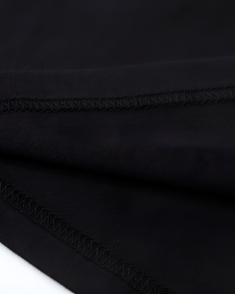 Close-up of the black fabric texture of the Chaos Neko Explosion Tee, showing the stitching details.