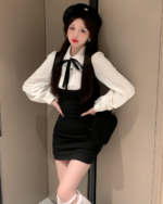 Woman wearing a Korean preppy mini dress with a black top and vest, accessorized with a beret.