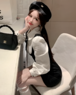 Woman wearing a Korean preppy mini dress, beret, and a black bag.