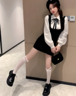 Woman wearing a Korean preppy mini dress with a black velvet bodice and white blouse.