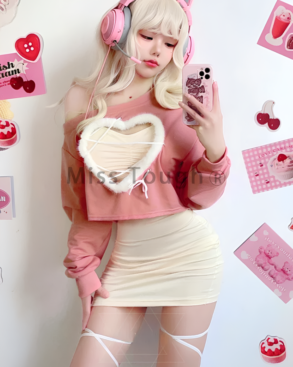 Model wearing a pink Korean style mini dress with a heart-shaped detail. The outfit features a matching skirt and top set.