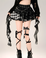 Model wearing a black and white plaid goth punk skirt with a lace trim and chain detail. Includes leg garters.